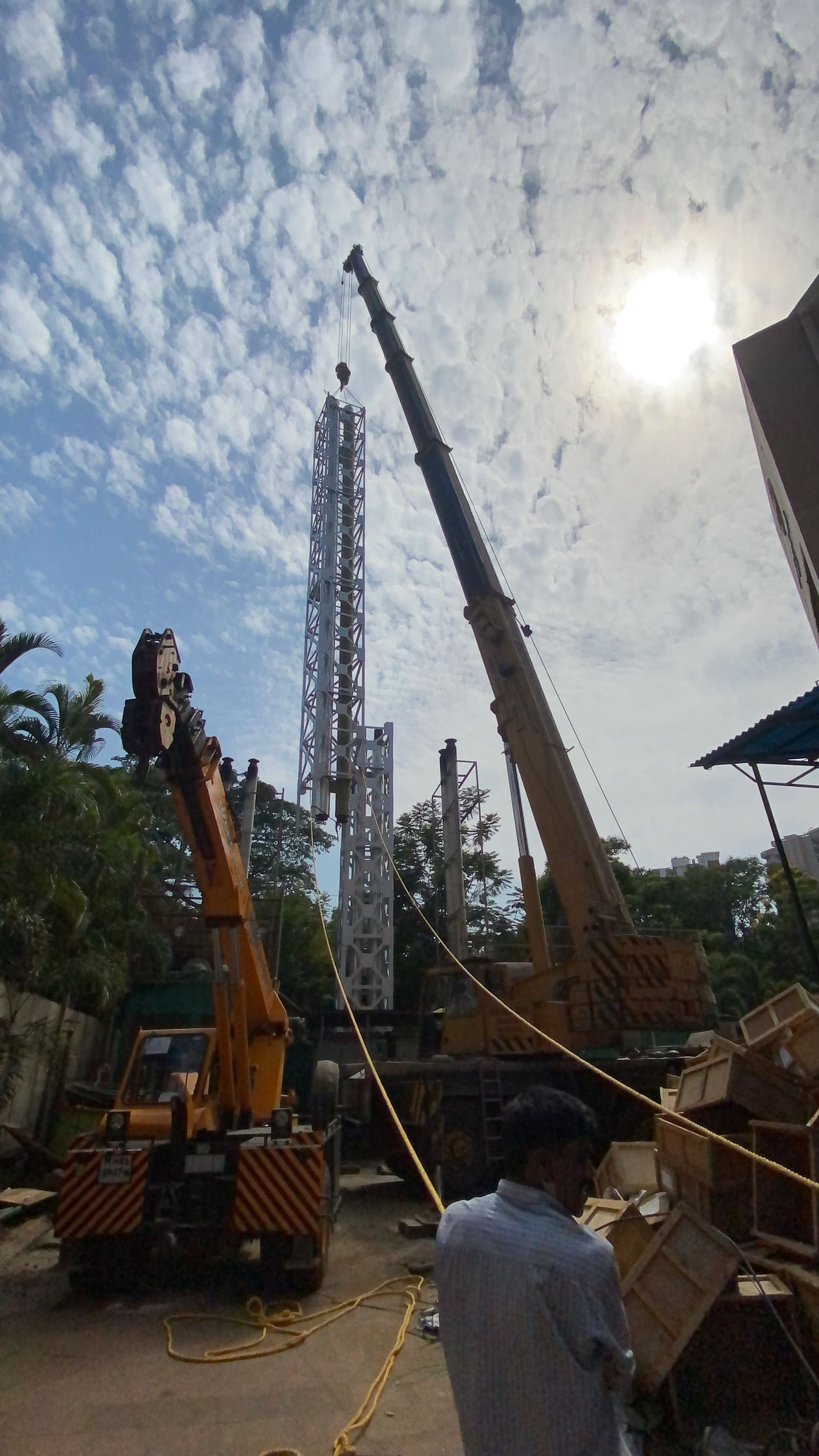 Mobile cranes rigged with a lattice stack section lying horizontal before the lift