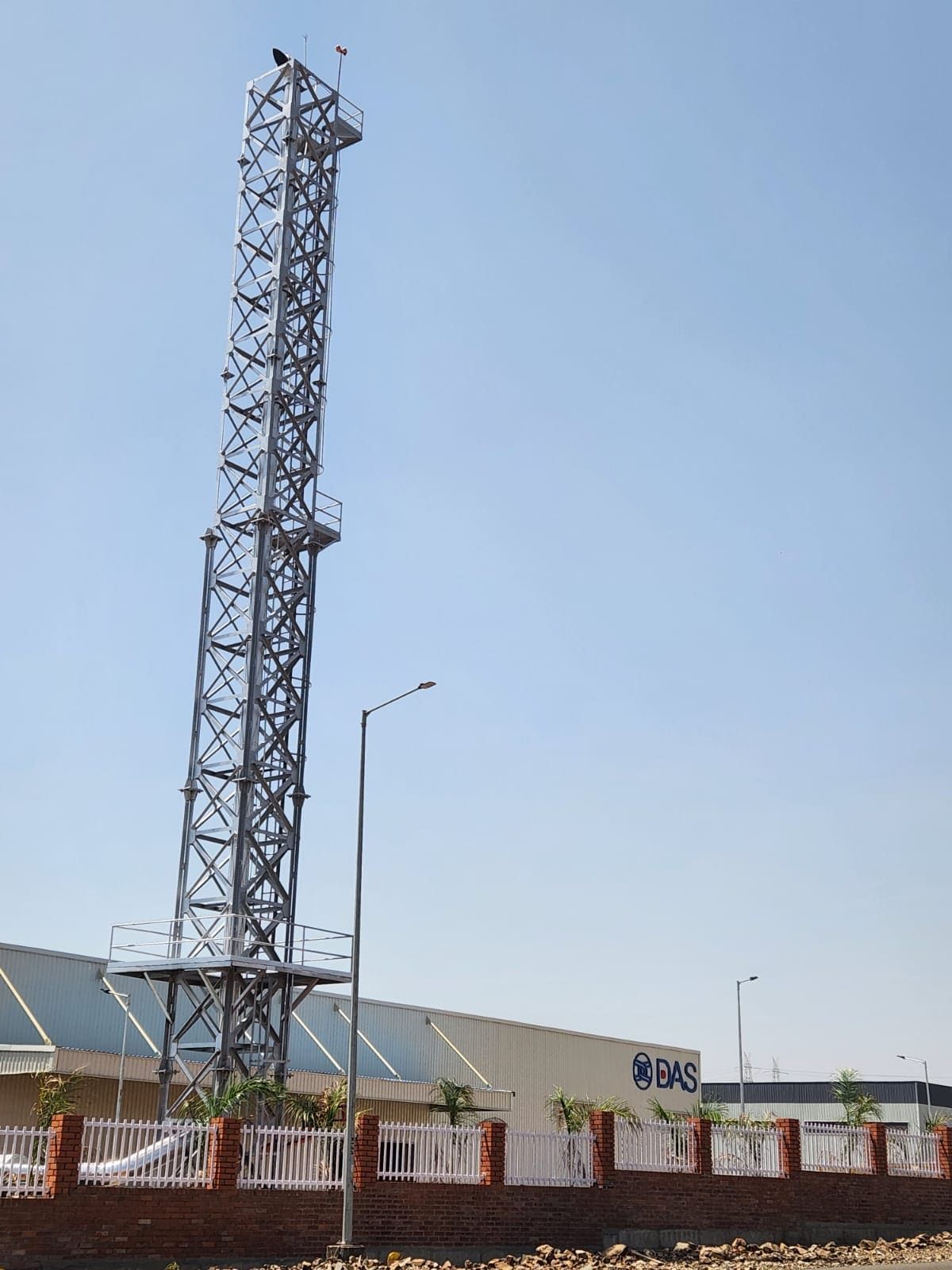 Completed 30 metre lattice stack beside the DAS Auto plant building with its signage