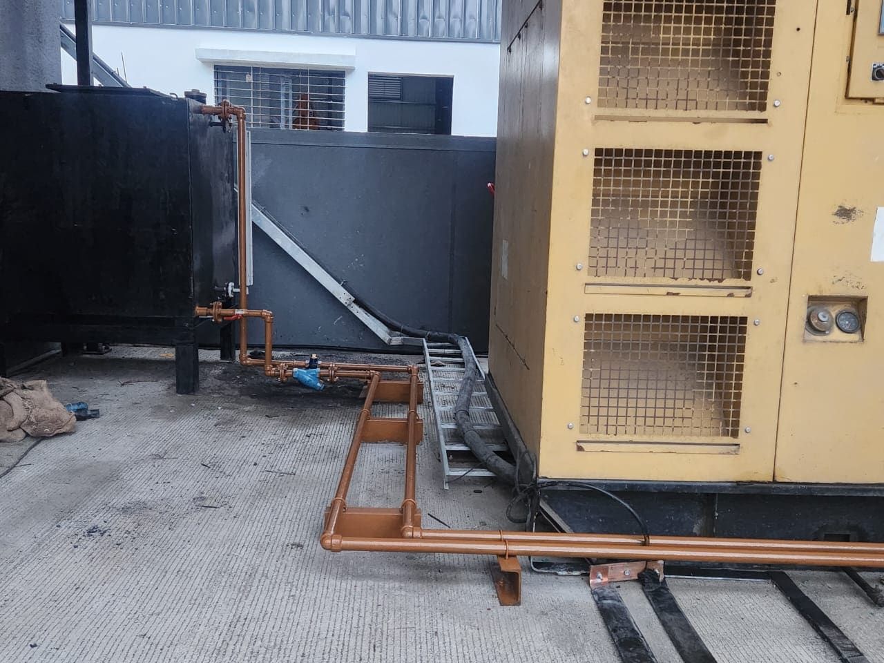 A fuel day tank with diesel line piping serving a DG set