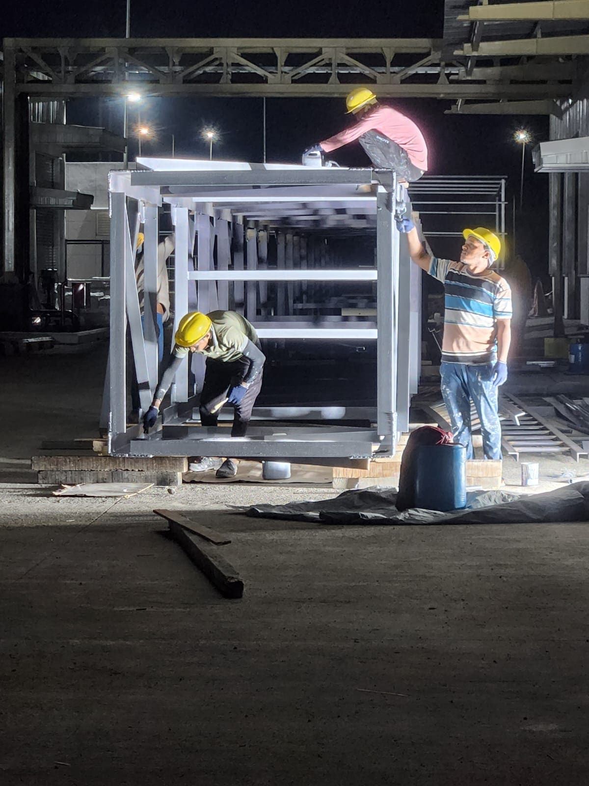 Night finishing work on a fabricated lattice stack section under floodlights