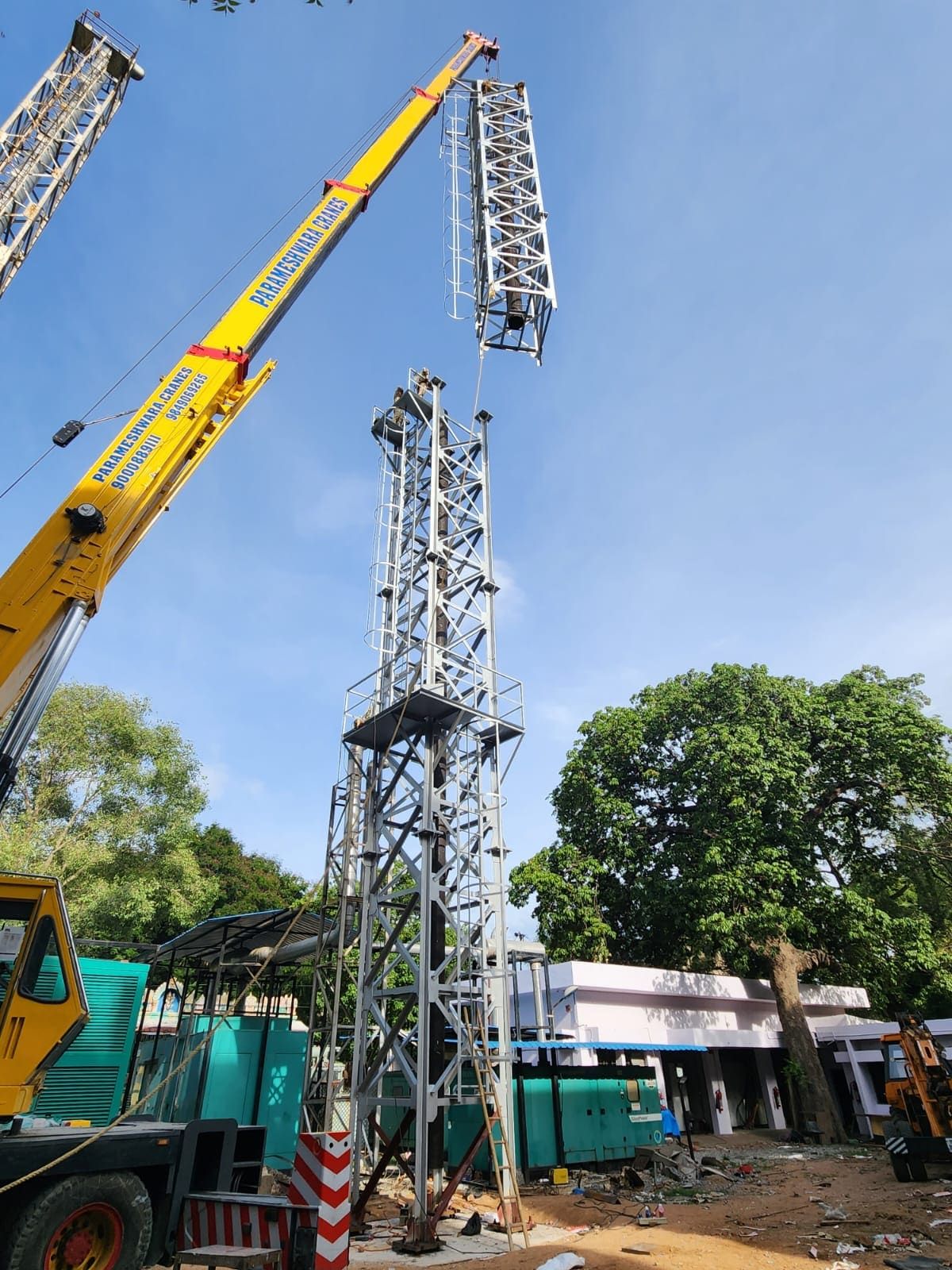 Crane lowering an upper lattice section onto the standing base section